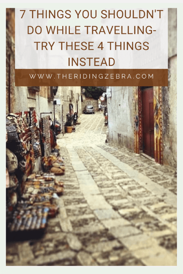 A graphic design with a photo of a cobblestoned street in the background and the title "7 Things You SHOULDN'T Do While Travelling"