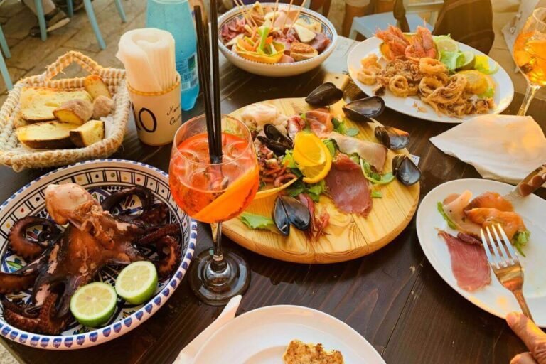 A table at a restaurant with various seafood dishes, typical of Sicilian cuisine