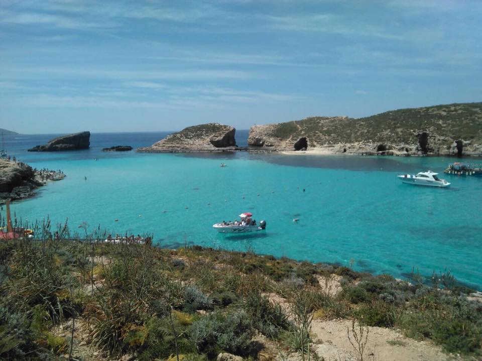 Clear blue Mediterranean sea with boats and rock formations