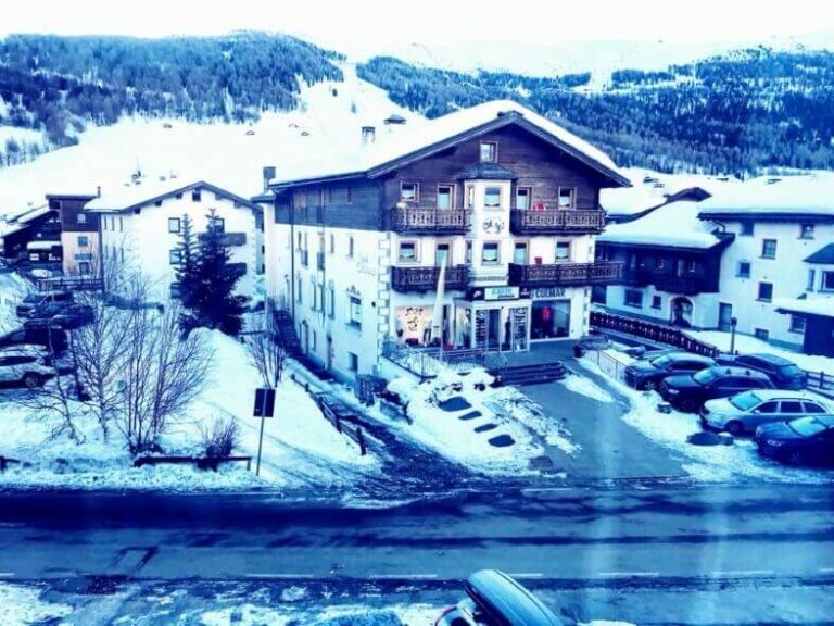 A mountain wood building in a valley with snow around. Livigno is a low-budget winter destination in Italy