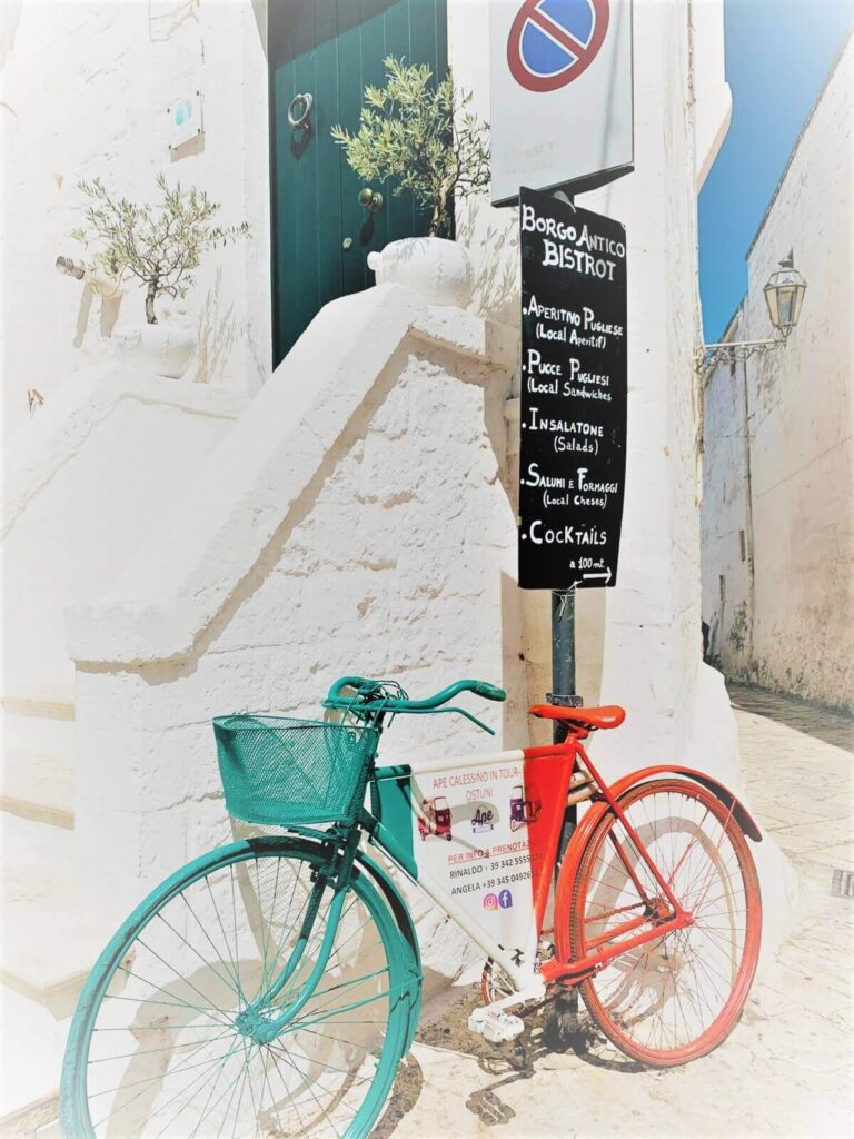 A doorstep with a bicycle in the green and red colours of the Italian flag