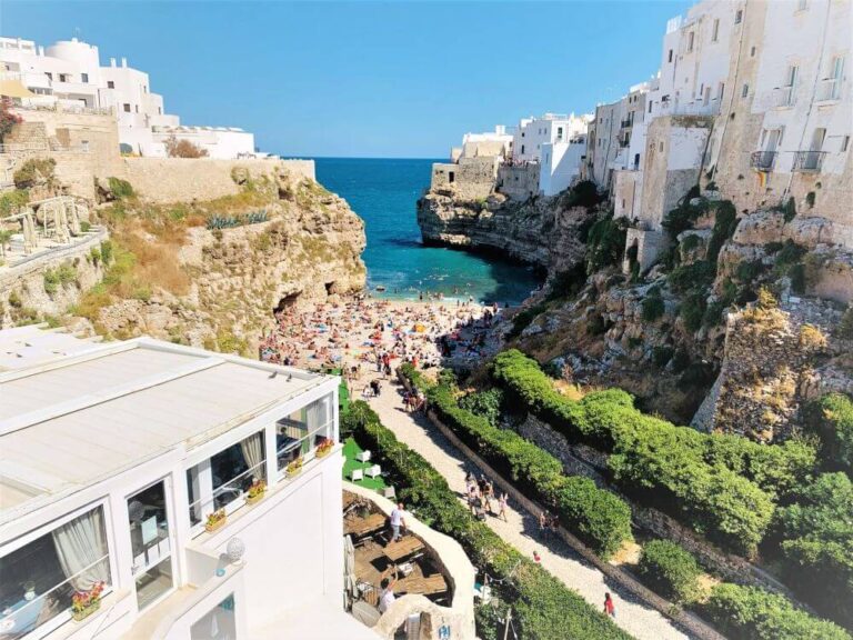 View of a town on a rock with a protected bay overlooking the clear blue sea