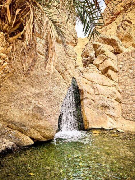 A small waterfall from a rock in an oasis in the desert