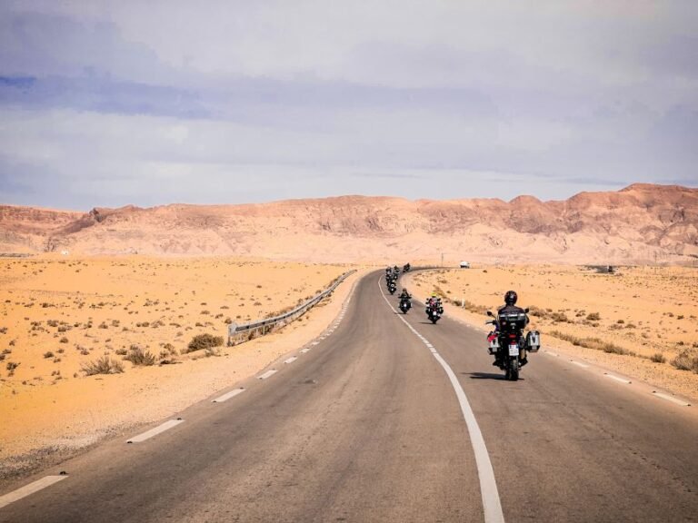 A road curving towards a mountain range in a desert landscape.