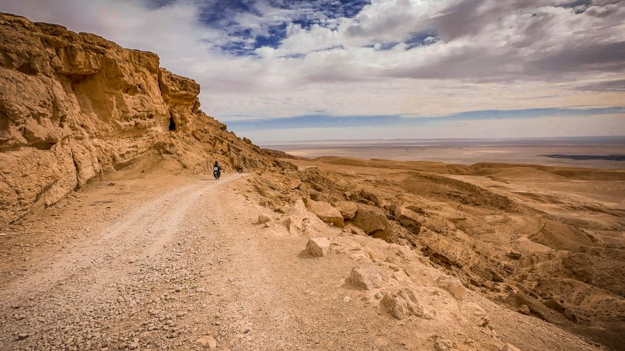 A rough road running along the side of a mountain in a desert region, Tunisia