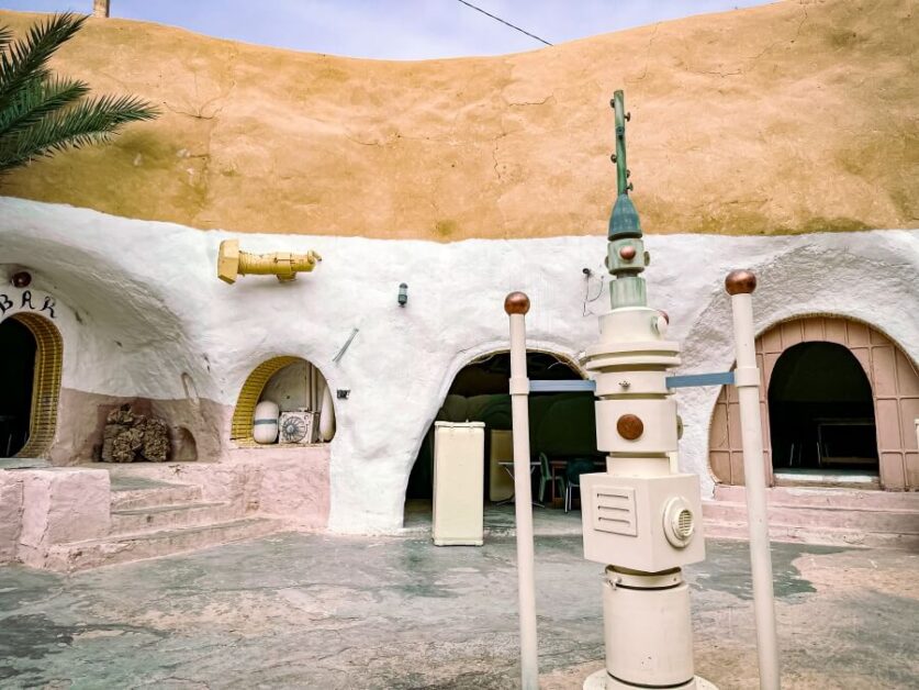 A circular courtyard of an underground cave hotel. There is a space observation device at the center