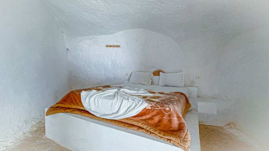 A bed in a troglodyte bedroom with wool blanket